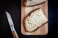 Traditional French country bread slices and pocket knife on a cutting board Royalty Free Stock Photo