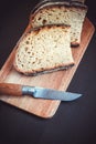 Traditional French country bread slices and pocket knife on a cutting board Royalty Free Stock Photo