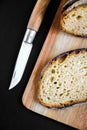 Traditional French country bread slices and pocket knife on a cutting board Royalty Free Stock Photo