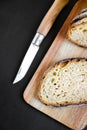 Traditional French country bread slices and pocket knife on a cutting board Royalty Free Stock Photo