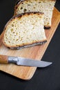 Traditional French country bread slices and pocket knife on a cutting board Royalty Free Stock Photo