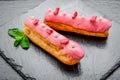 Traditional French dessert. Eclair with chocolate icing and raspberries. Royalty Free Stock Photo