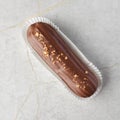 Traditional french dessert. eclair with custard and milk chocolate icing on a stone background. Pastry products for Royalty Free Stock Photo