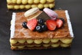 Traditional French dessert millefeuille with vanilla cream and fresh berries on Baking Tray Dark Background