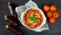 Traditional French dish quiche with eggplants and tomatoes in the baking dish decorated with fresh basil leaves. Vegetable tart Royalty Free Stock Photo