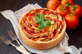 Traditional French dish quiche - pie with eggplants and tomatoes. Homemade vegetable tart on the black wooden background