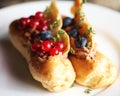 Traditional french eclairs on white plate close up