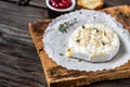 Traditional French homemade baked Camembert cheese with thyme and baguette bread on wooden table Royalty Free Stock Photo