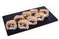 Traditional fresh japanese sushi on black stone Warm mussel roll on a white background. Roll ingredients: mussel, philadelphia