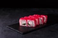 Traditional fresh japanese sushi rolls on a black stone California ebi . Roll ingredients: crab, cucumber, red tobik caviar, nori