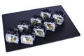 Traditional fresh japanese sushi rolls on a black stone Murugai on a white background. Roll ingredients: algae hiyashi, nori, rice Royalty Free Stock Photo