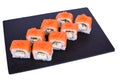 Traditional fresh japanese sushi rolls on black stone Philadelphia Ikura on a white background. Roll ingredients: salmon,