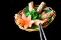 Traditional fried vietnamese spring rolls with pork, rice paper on black background side view with chopsticks