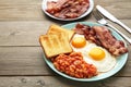 Traditional full English breakfast - fried eggs, beans, bacon and toast on grey wooden background with copy space for text Royalty Free Stock Photo