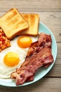 Traditional full English breakfast - fried eggs, beans, bacon and toast on grey wooden background. Vertical foto Royalty Free Stock Photo