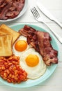 Traditional full English breakfast - fried eggs, beans, bacon and toast on white table. Vertical foto Royalty Free Stock Photo