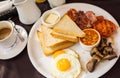 Traditional Full English Breakfast with sunny-side-up fried eggs, bacon, sausages, beans in tomato sauce, toasts, fried Royalty Free Stock Photo