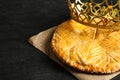 Traditional galette des Rois with decorative crown on black table