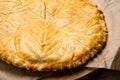 Traditional galette des rois on wooden board, closeup