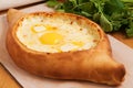 Traditional Georgian cuisine. Ajara khachapuri on a wooden Board