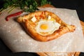 Traditional Georgian dish khachapuri ajarian in the black background. Freshly Baked Khachapuri. National Georgian pastries with ch