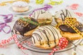 Traditional german Berliner pastries glazed with dark and white chocolate and hazelnut brittle, decorated for party or carnival