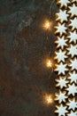 Traditional German Christmas Cookies Home Baked Glazed Cinnamon Stars with Nuts Sparkling Garland Lights on Rusty Dark Background