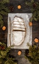 Traditional German Christmas fruit cake stollen on a dark background, around the fir branches and walnuts. View from above,copy s