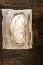 Traditional German Christmas fruit cake stollen on a dark background, around the fir branches and walnuts. View from above,copy s