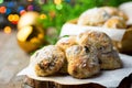 Traditional German Christmas pastry mini stollen on parchment paper on plank wood table. Fresh green juniper branch golden balls