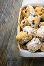 Traditional German Christmas pastry mini stollen in wicker basket on plank wood table. Rustic vintage style