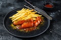 Traditional German currywurst, served with French fries. Black background. Top view Royalty Free Stock Photo