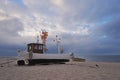 Traditional german fishing boat on the beach of Baltic sea in the sunset before storm. Royalty Free Stock Photo