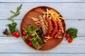 Traditional German Grilled sausages with tomatoes wooden pan on a wood table background. Top view