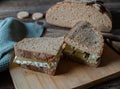 Rye bread with sour milk cheese and butter on wooden cutting board