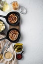 Traditional German Sausages with Mashed Potatoes and Sauerkraut in cast iron frying pan  on white background  top view flat lay Royalty Free Stock Photo