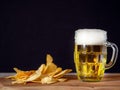 Traditional glass with lager beer and crisps. Still life. Dark background. Crisps and ale. Food and alcohol industry products Royalty Free Stock Photo