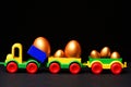 Traditional golden eggs in plastic colorful car toy or locomotive Royalty Free Stock Photo
