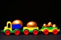 Traditional golden eggs in plastic colorful car toy or locomotive Royalty Free Stock Photo
