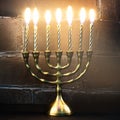 Traditional golden Hanukkah candleholder and candles on dark bac