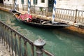 Traditional gondola moored in water canal in Venice