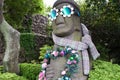 Traditional Harubang statue of Jeju Island decorated with flowers, sunglasses, and scarf in Camellia Hill, South Korea.