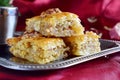 Traditional Greek baklava made with filo dough, sugar syrup and wallnuts on a metal tray with metal coffee cup on a Royalty Free Stock Photo