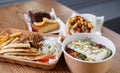 Traditional Greek fast food meal served in recyclable paper dishware. Pita souvlaki meat, fries, white tzatziki sauce and fresh Royalty Free Stock Photo