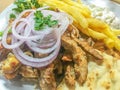 Traditional Greek gyros plate with fries and salad. Royalty Free Stock Photo