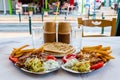 Traditional Greek hot dish Gyro or Gyros served on the plates. Pork or chicken meat, flat bread pita, tomato, tzatziki sauce, and Royalty Free Stock Photo