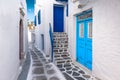 Traditional greek house with blue door and staircase in narrow city alley. Mykonos Island, Greece. Royalty Free Stock Photo