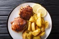 Traditional Greek Lemon Garlic Roasted Potatoes Patates fournou with grilled chicken thighs on a plate close-up. Horizontal top