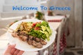 A traditional greek pork souvlaki plate over a tavern background. Welcome to Greece concept Royalty Free Stock Photo