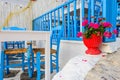 Traditional Greek restaurant on the open air with bright blue chairs and flowers Royalty Free Stock Photo